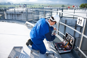 Service technician installing guided wave radar on top of a tank